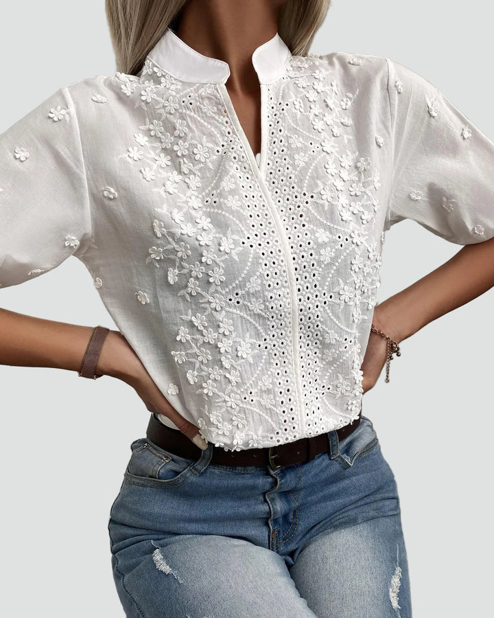 Blouse blanche élégante avec broderie florale et col montant