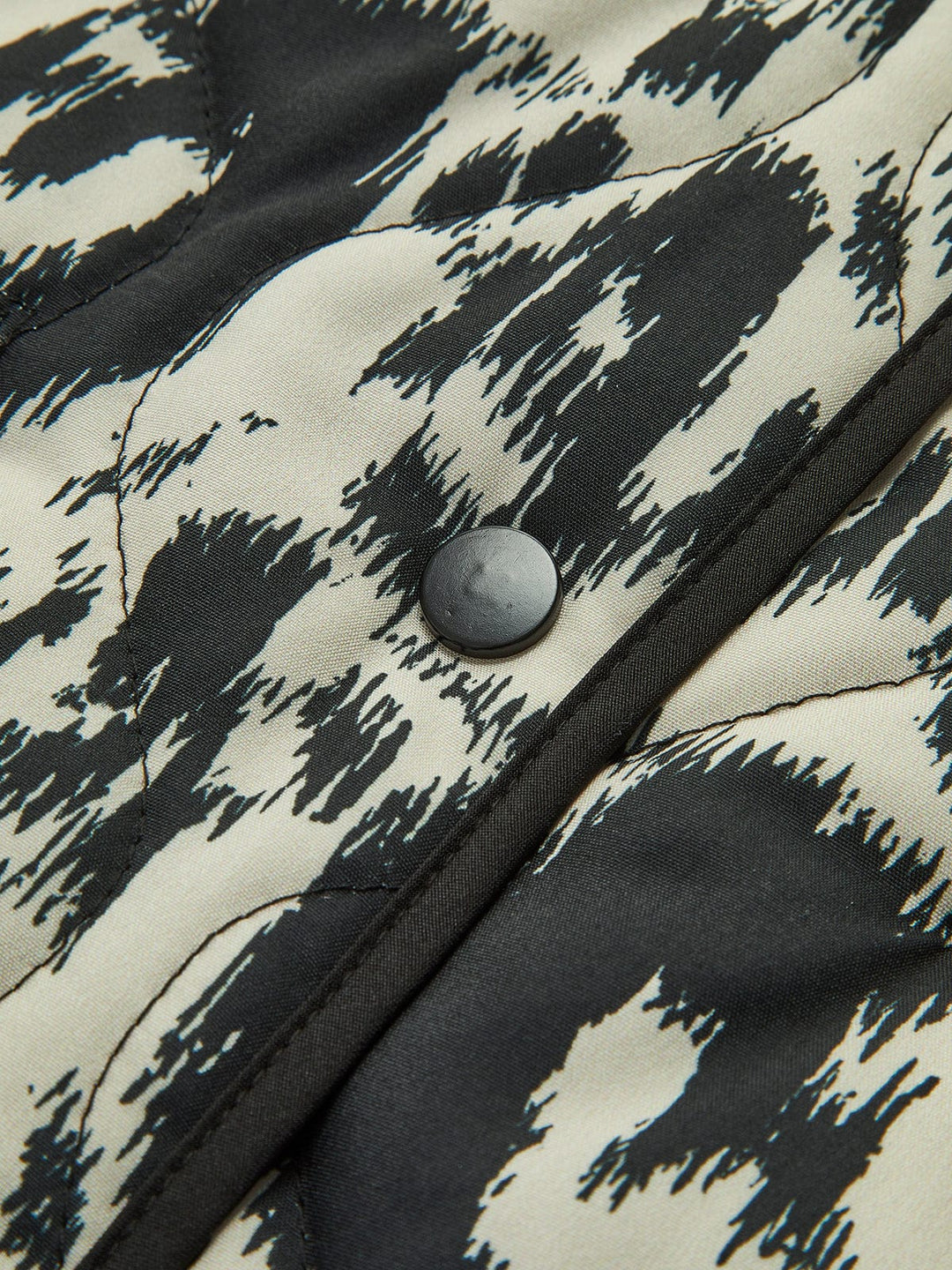 Patterned quilted jacket without collar with decorative trim