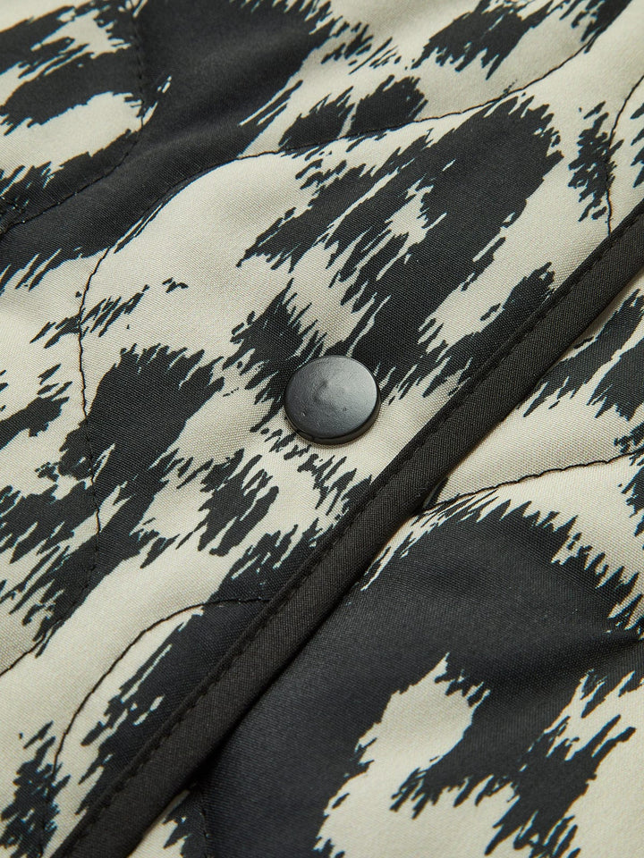 Patterned quilted jacket without collar with decorative trim