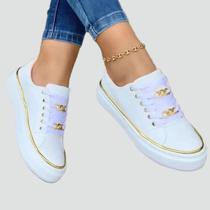 Stylish women's sneakers with a thick sole and decorative detail