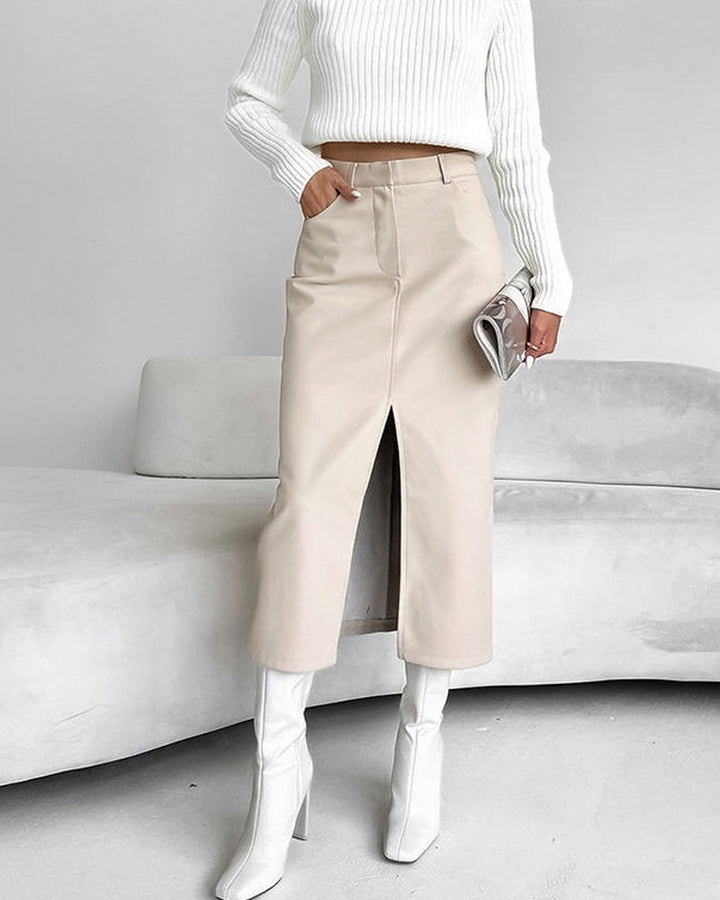 beige midi rok met split aan de voorkant, gecombineerd met witte laarzen en een witte trui